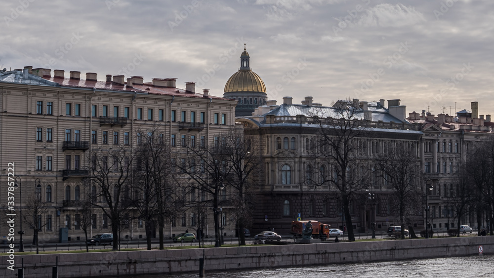 Fototapeta premium Buildings on the banks of the Neva and the gilded dome of St. Isaac's Cathedral.