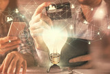 Double exposure of man and woman on-line shopping holding a credit card and light bulb hologram drawing. Idea concept.