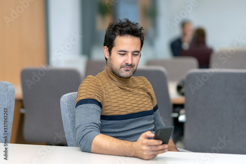 A handsome man texting with his lover on a smartphone