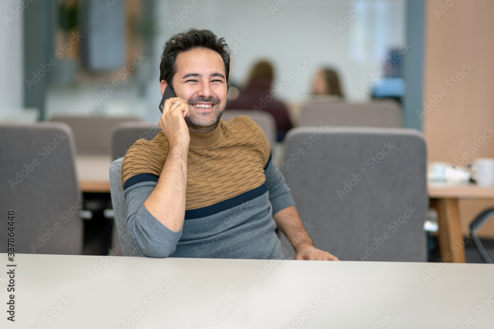 Naklejka premium A handsome man who happily talks to his lover on a smartphone