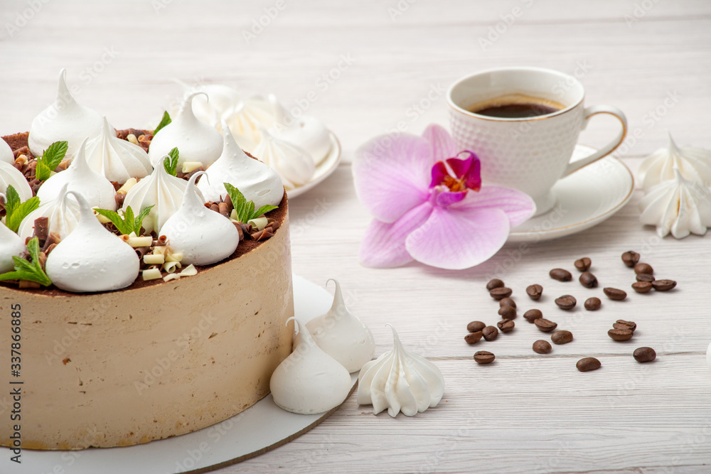 Delicious brown cake with marshmallows and a cup of coffee