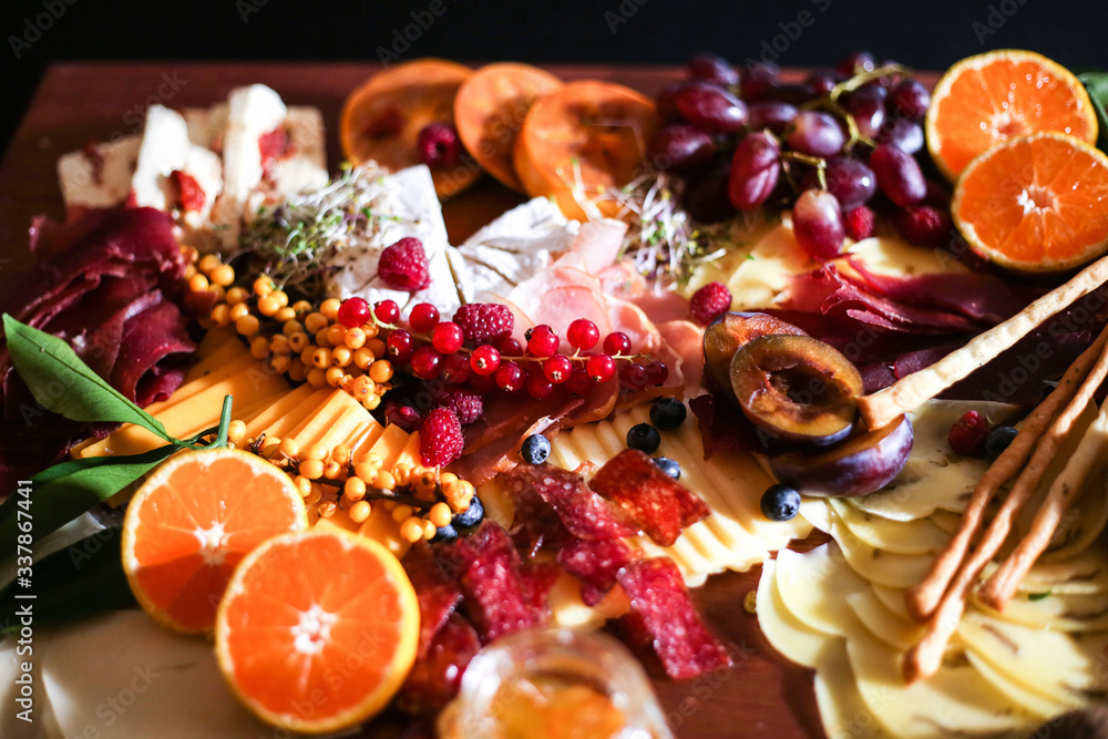 slicing meat, cheese, various fruits on a wooden Board.