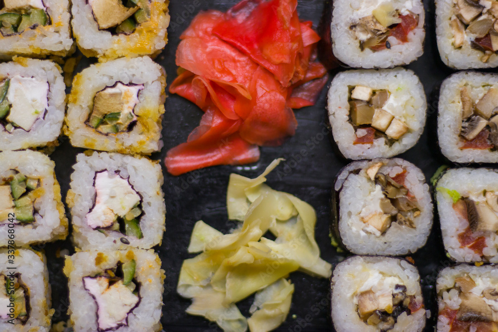 japanese cuisine different rolls with black chopsticks red pickled ginger wasabi sauce and soy sauce on the table japanese cuisine different rolls with black chopsticks red pickled ginger wasabi sauce and soy sauce on the table
