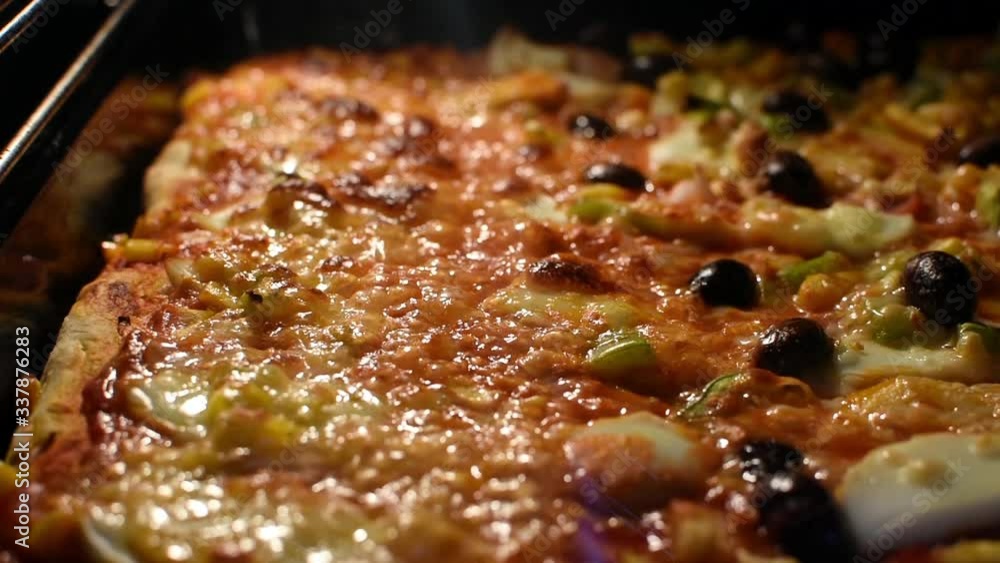 Homemade delicious pizza baking in the oven, cheese melting Homemade delicious pizza baking in the oven, cheese melting