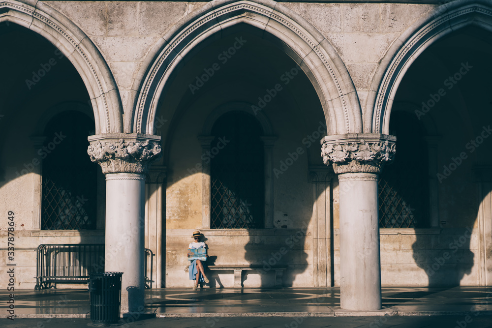 Obraz premium Romantic woman looking at map on bench in sunlight