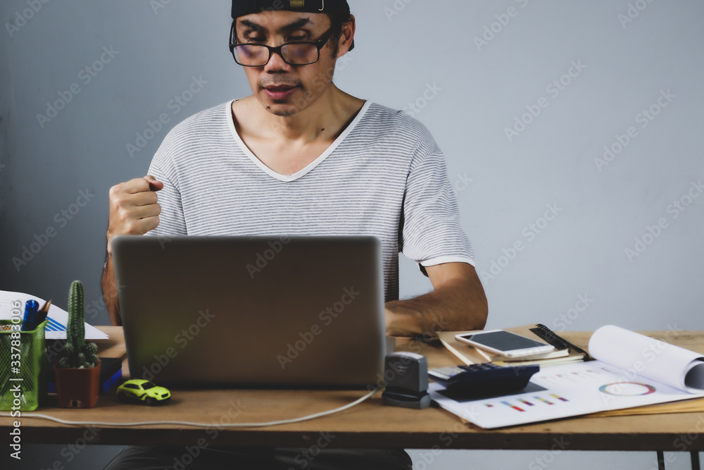 Asian man working from hone online because of covid-19. Work at home and social distancing concept. Selective focus.
