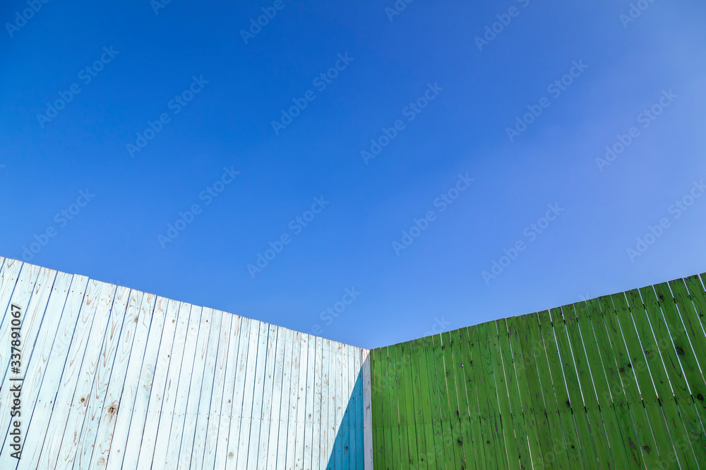 Fototapeta premium 青と緑色に塗装された古びた板塀のコーナー。背景用素材