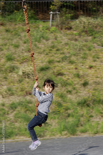 ターザンロープで遊ぶ幼児(5歳児)