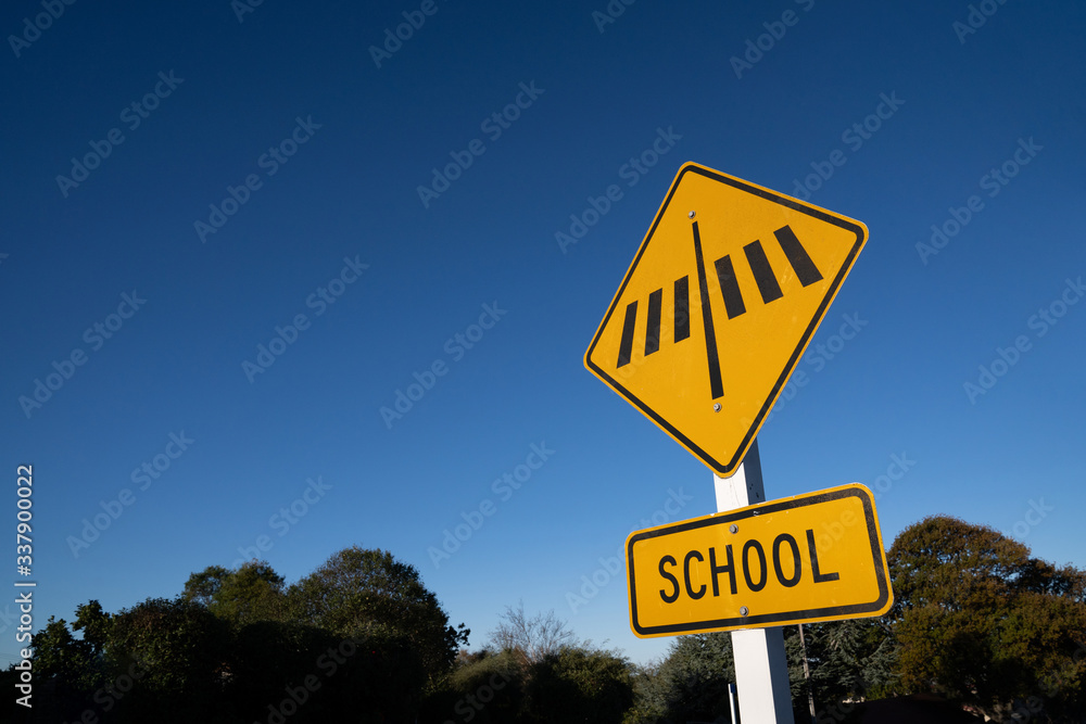 School crosswalk sign with blue sky.