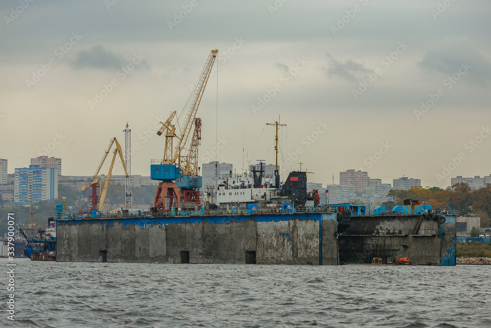 Summer, 2015 - Vladivostok, Russia - The marine facade of Vladivostok. Industrial ship stands in a dry dock during repair at a shipyard
