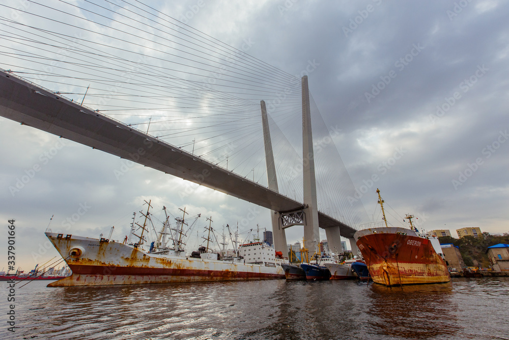 Fototapeta premium Industrial zone in the Zolotoy Rog Bay in Vladivostok. Ships stand under the Golden Bridge