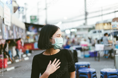 Asian woman suffer from cough with face mask protection,woman wearing face mask because of air pollution in the city building,Sick woman with medical mask;concept of pollution,dust allergies