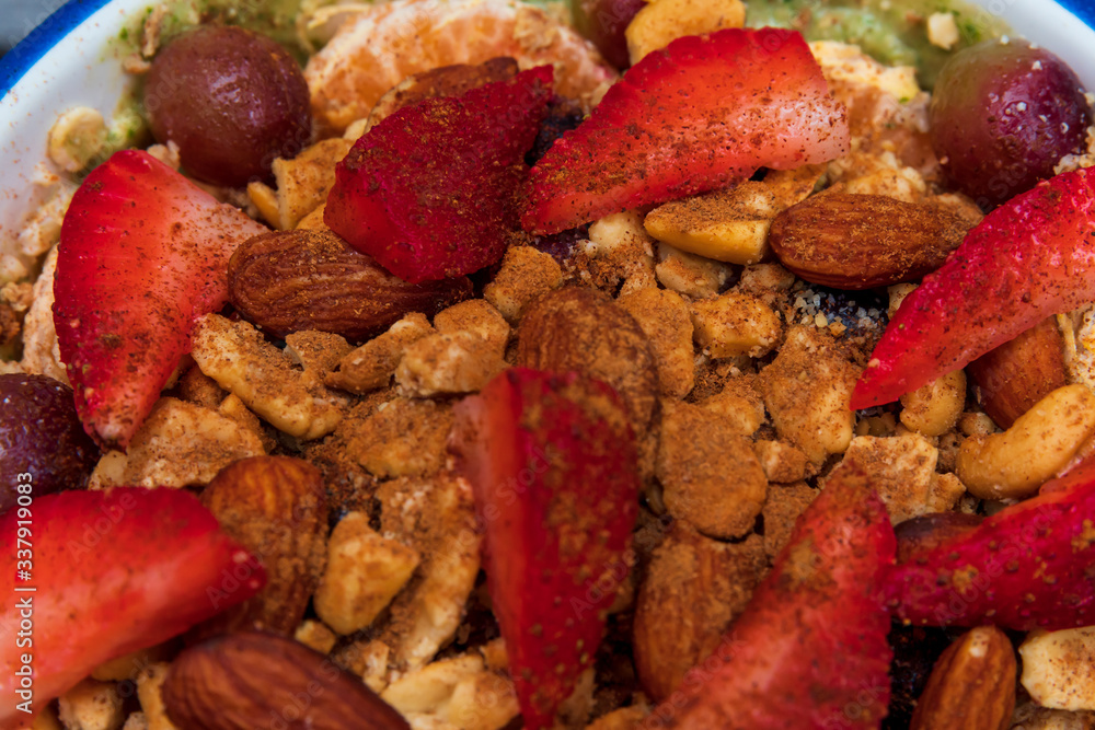 A smoothie bowl with oats, almond milk, almond yogurt, spinach, banana, berries, sliced strawberries, grapes topped with crushed almonds, almonds, Ezekiel cereal and a splash of cinnamon A smoothie bowl with oats, almond milk, almond yogurt, spinach, banana, berries, sliced strawberries, grapes topped with crushed almonds, almonds, Ezekiel cereal and a splash of cinnamon