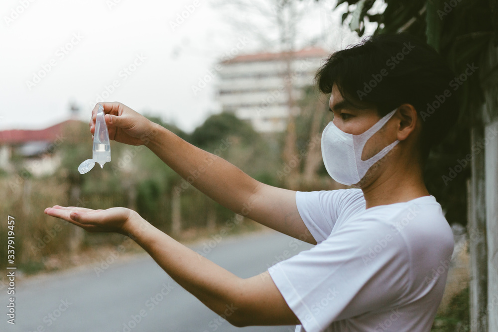 Asian man using alcohol antiseptic gel and wearing mask,prevent against infection of Covid-19 outbreak,woman washing hands with hand sanitizer to avoid contaminating with Corona virus Asian man using alcohol antiseptic gel and wearing mask,prevent against infection of Covid-19 outbreak,woman washing hands with hand sanitizer to avoid contaminating with Corona virus