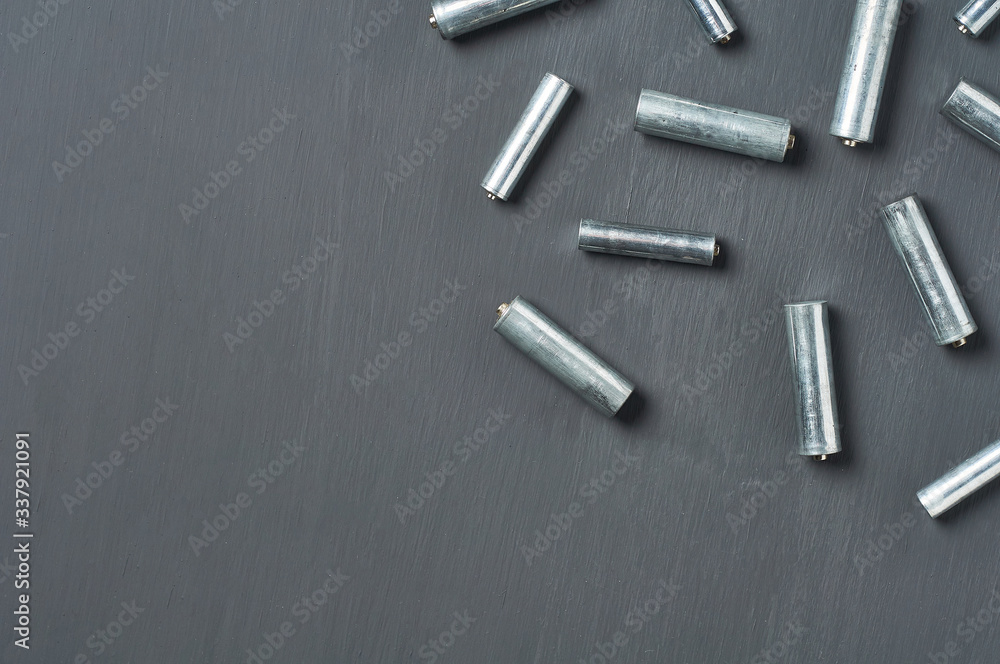Scattered old dirty batteries aa or aaa size on dark concrete desk. Recycling concept. Save environment. Alternative energy Scattered old dirty batteries aa or aaa size on dark concrete desk. Recycling concept. Save environment. Alternative energy