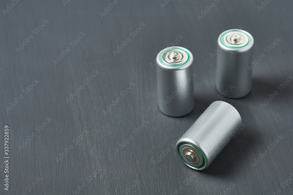 Old used batteries on dark concrete desk. Recycling concept. Save environment. Alternative energy Old used batteries on dark concrete desk. Recycling concept. Save environment. Alternative energy