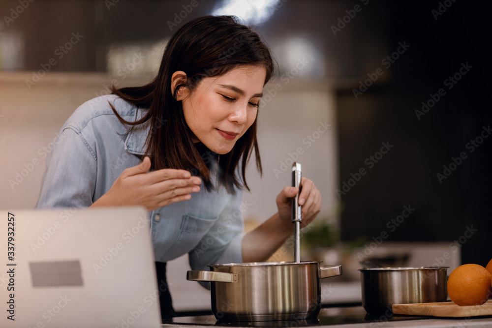 E-Learning Concept. Young Woman Try to Practice and Learn for Cooking at Home via the Internet E-Learning Concept. Young Woman Try to Practice and Learn for Cooking at Home via the Internet