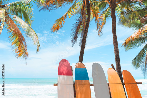 Surfboard and palm tree on beach background.