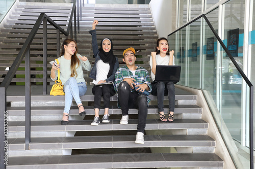 Young asian malay chinese man woman indoor stair corridor campus book file folder laptop computer phone sit stand mingle talk study joy