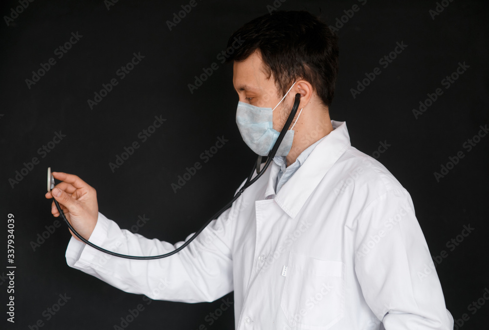 Male Doctor on a black background with a stethoscope in his hands close-up Male Doctor on a black background with a stethoscope in his hands close-up