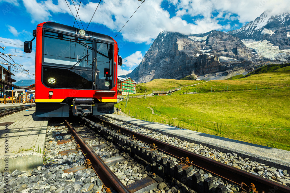 Electric red passenger train parked in the mountain station, Switzerland