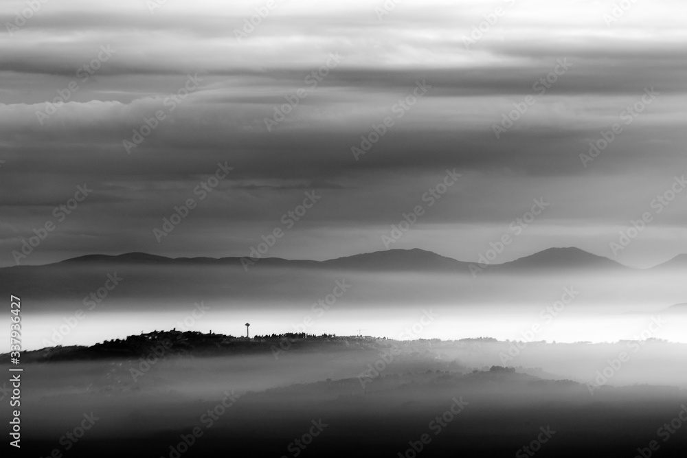 Sea of fog and mist between mountains and hills, with Montefalco town (Umbria, Italy) on the foreground