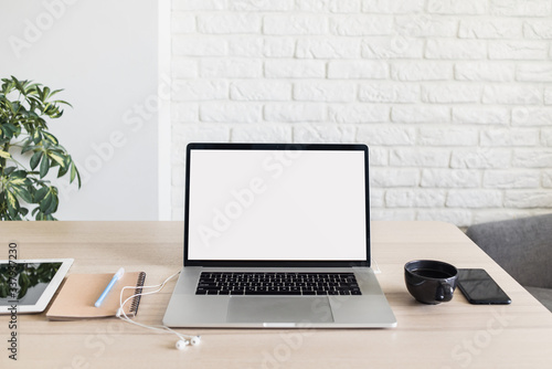 Laptop computer mockup, place of work, home office, notebook, coffee cup, smartphone at desk. Work from home, freelance, business, distance education, online learning, studying concept