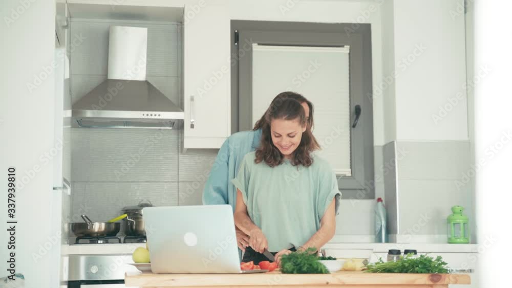 Two young pretty caucasian women cooking in the bright kitchen. Friends are having fun while cooking together. Two young pretty caucasian women cooking in the bright kitchen. Friends are having fun while cooking together.