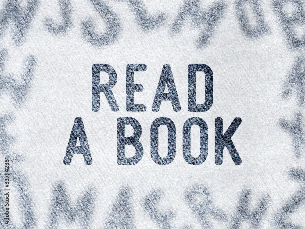 READ A BOOK - Words on paper surrounded by blurry letters READ A BOOK - Words on paper surrounded by blurry letters