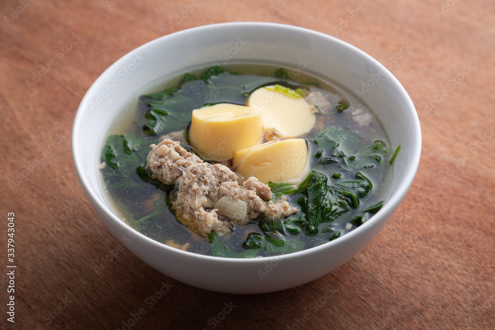 Boiled minced pork and tofu soup with gourd in white bowl on wooden table, Thai food, Healthy food. Boiled minced pork and tofu soup with gourd in white bowl on wooden table, Thai food, Healthy food.