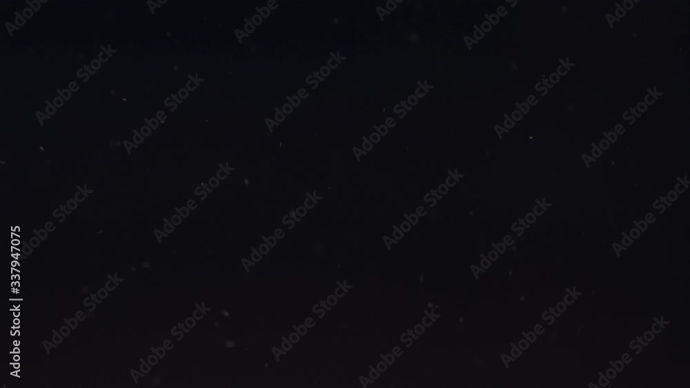 Particle dust cloud dynamically floating with turbulent wind on black background 4k Particle dust cloud dynamically floating with turbulent wind on black background 4k