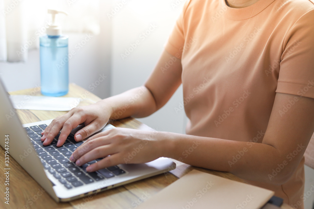 Naklejka premium Woman working from home. wearing protective mask. COVID-19 Pandemic Coronavirus home isolation auto quarantine wearing face mask protective for spreadingWorking from home and Cleaning hands