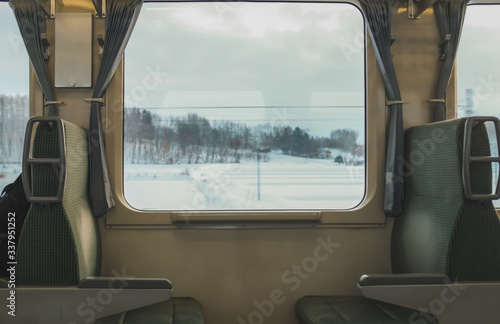 Snow-covered mountain views from the local train window between cities in Hokkaido to furano