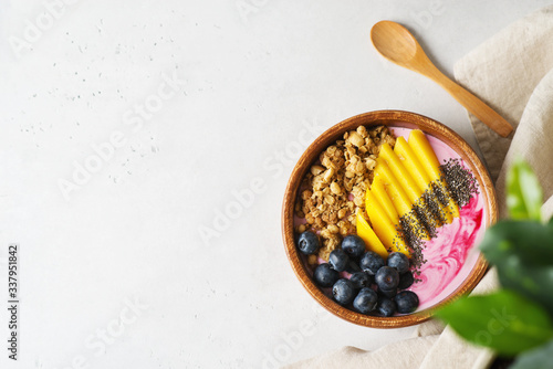 Asai bowl granola oatmeal with mango, blueberry and chia seeds in wooden plate on white background photo