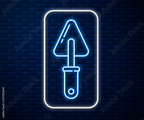 Glowing neon line Trowel icon isolated on brick wall background. Vector Illustration