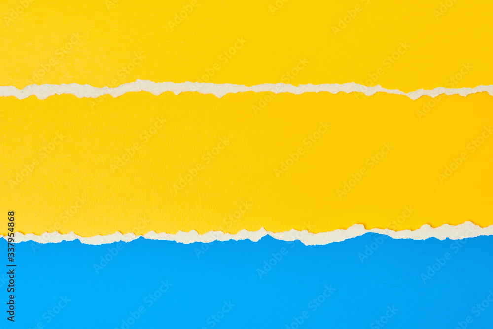 Torn ripped paper edge with a copy space, color blue and yellow background Torn ripped paper edge with a copy space, color blue and yellow background