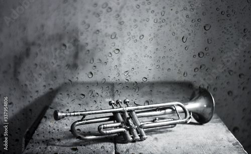 the ancient jazz trumpet behind the window with rain drops