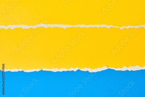 Torn ripped paper edge with a copy space, color blue and yellow background © Lazy_Bear