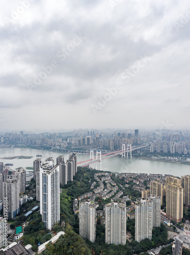 Fototapeta Naklejka Na Ścianę i Meble -  Aerial drone shot of Caiyuanba Bridge over Yangtze river and dense riverside residential building along in Chongqing, China