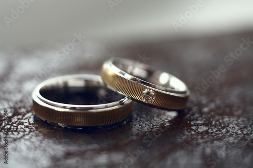 Two gold wedding rings with one diamond.