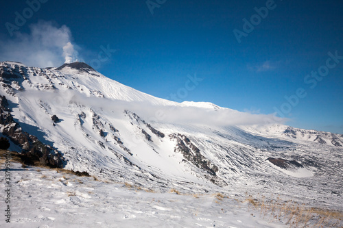 Mount Etna with snow, The active volcano with smoke and ash is coming from the crater. Etna National Park, Sicily, Italy