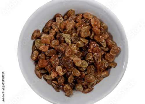 Raisins in a white plate isolated on a white background. Ingredient for desserts, pastries and sweet dishes. Close-up. View from above.