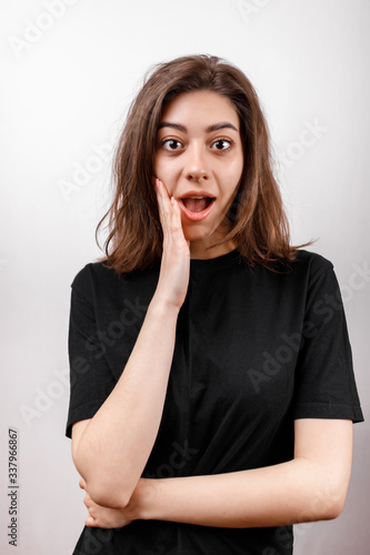 brunette woman on a white background in a black shirt. emotions