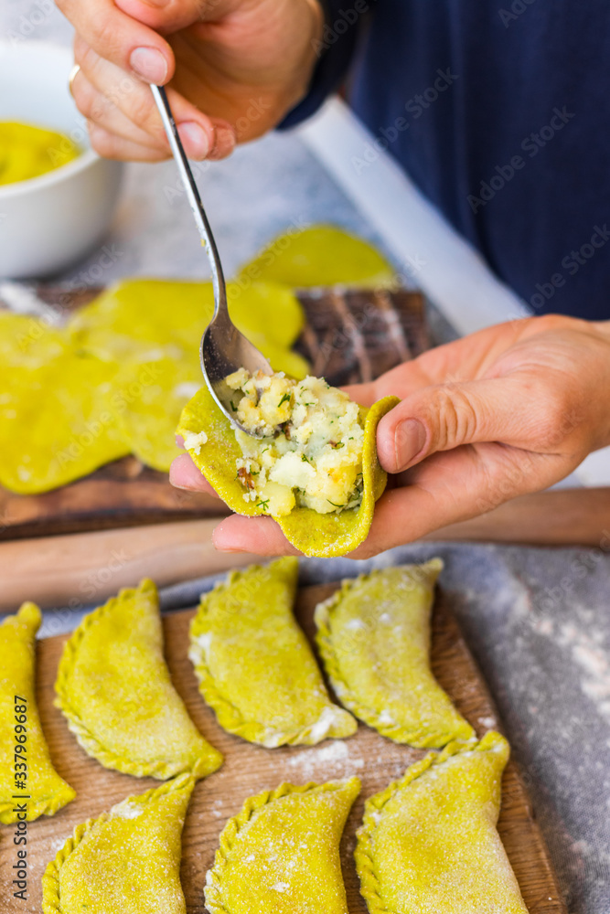 Φωτογραφία Woman hands making pierogi - European traditional cooked whole wheat dumplings with filling of potato, cabbage and greens