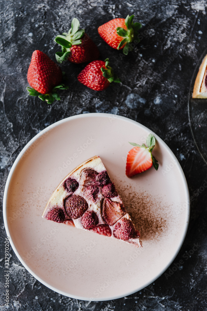 Slice of cheesecake with strawberries and raspberries on a pink plate. Slice of cheesecake with strawberries and raspberries on a pink plate.