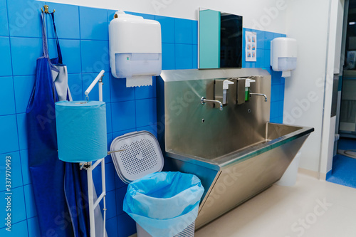 Hand wash room in the hospital. Sterile steel washbasin in modern surgery room photo