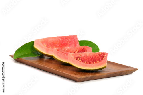 Fresh Psidium guajava / common guava / lemon guava sliced and raw fruit on a wooden plate isolated on a white background