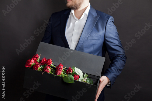 man gives red roses in an original box to his beloved woman