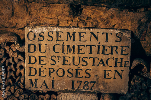 underground catacombs full of bones, gravestones and inscriptions photo