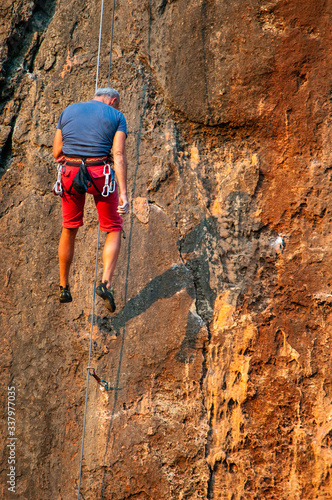 man climber on a rock with rope